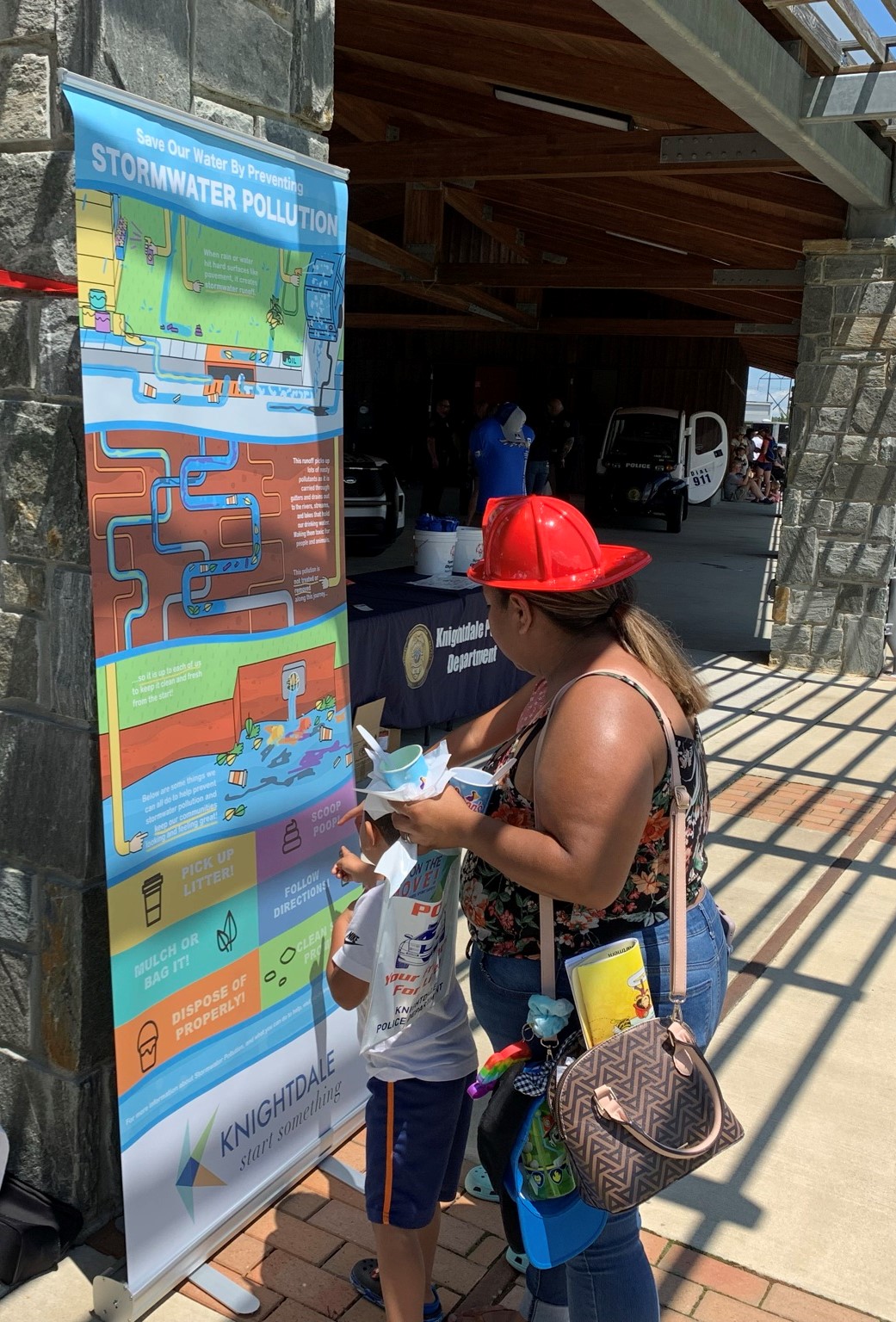 Family reading CWEPs clean water education poster and town event