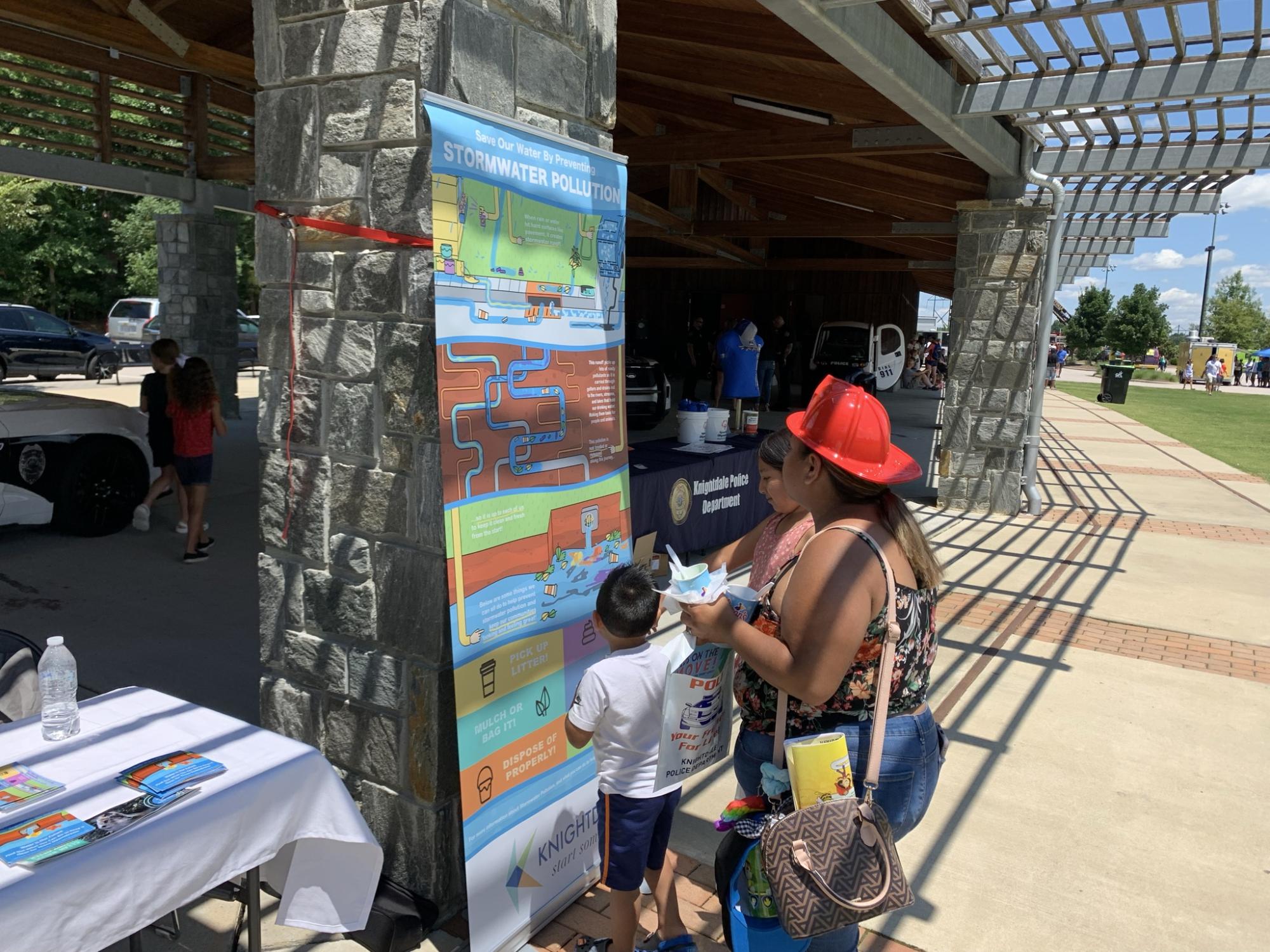 family reading CWEP education poster at town hosted event 