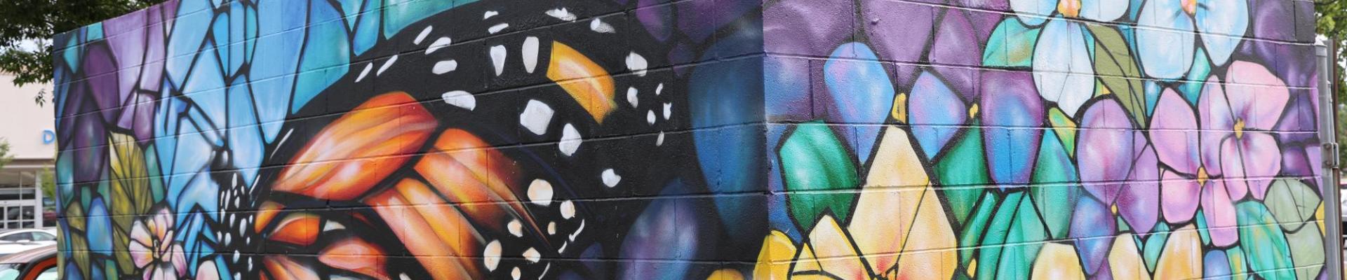 Mural with a butterfly landing on flowers.