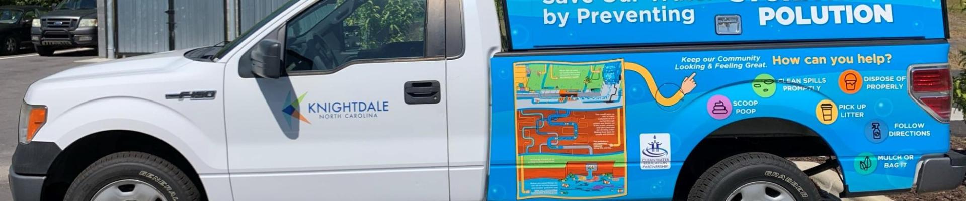 SW Fleet vehicle displaying stormwater education materials and IDDE hotline 