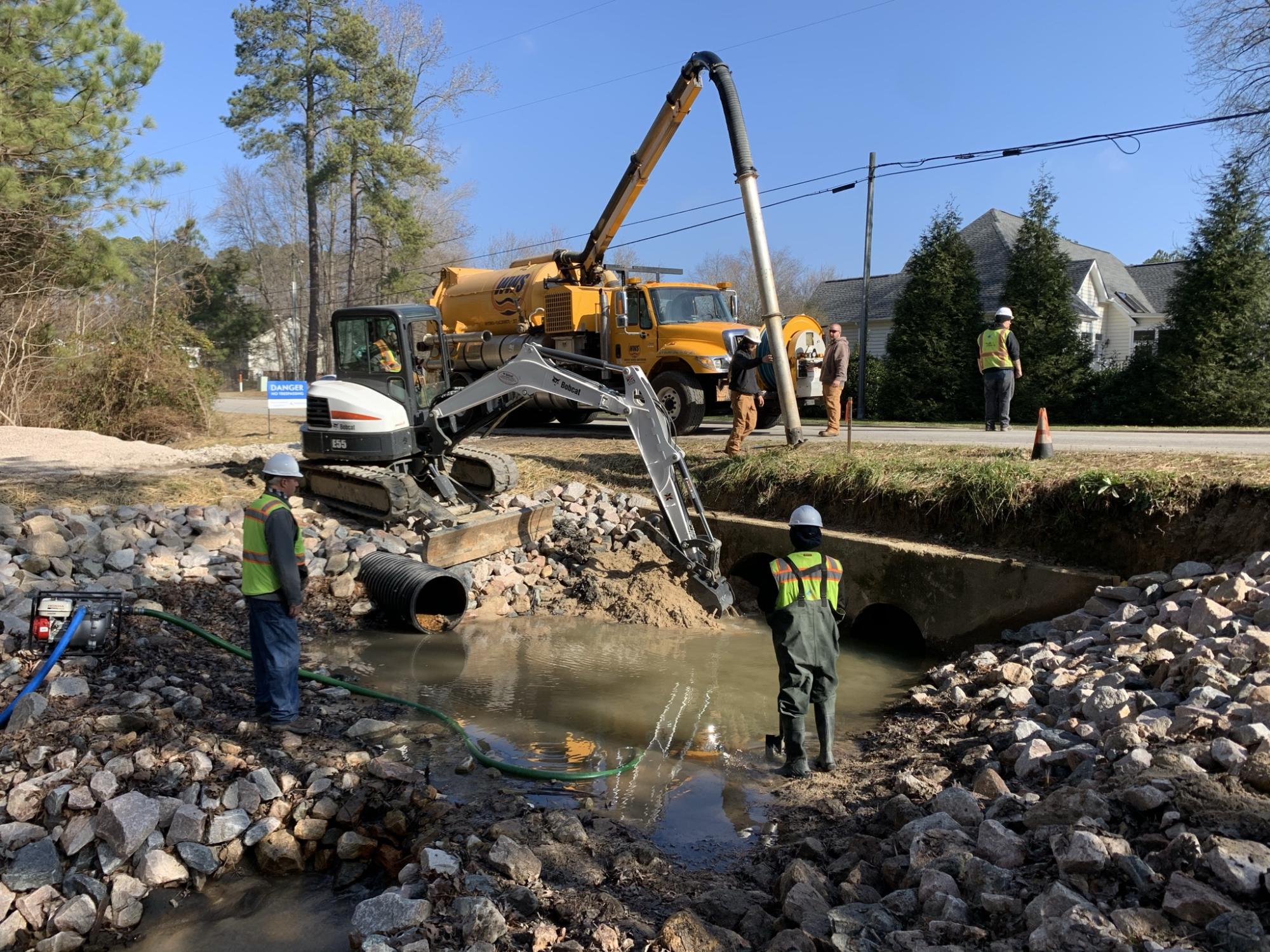 Crews vacuuming sediment out of plunge pool